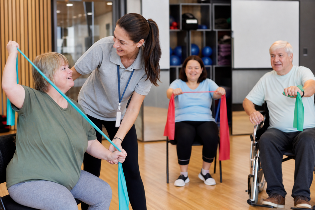 Support worker helping a group of people with disabilities during fitness activities at a community centre