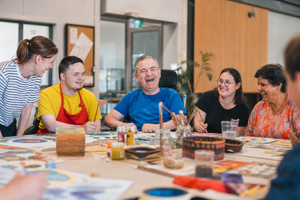 Group of people with disabilities participating in arts and crafts activities at a community centre